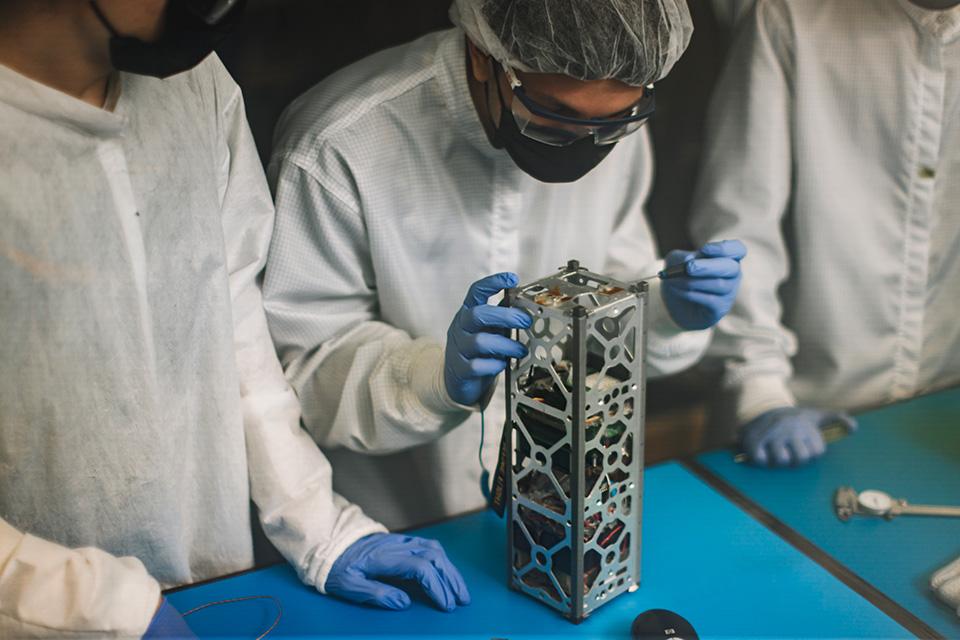 A student working on a satellite in the SSRL.